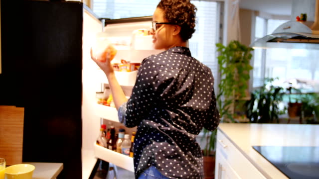 Woman removing can food from refrigerator 4k