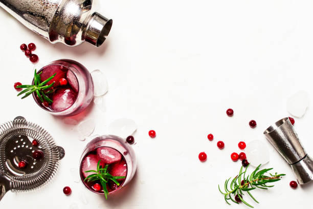 Red cranberry cocktail with ice, rosemary and vodka Red cranberry cocktail with ice, rosemary and vodka, bar tools, white background, top view vodka soda top view stock pictures, royalty-free photos & images