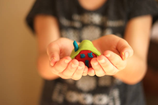 child's hand holding small play-doh house - playdoh imagens e fotografias de stock