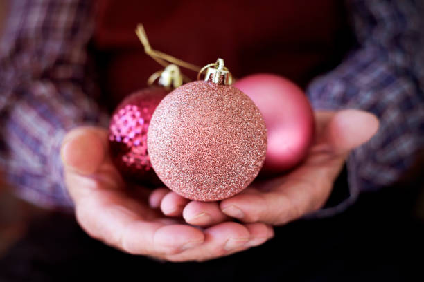 彼の手でクリスマス ボールを持つ老人 - christmas ball christmas ornament human hand ストックフォトと画像