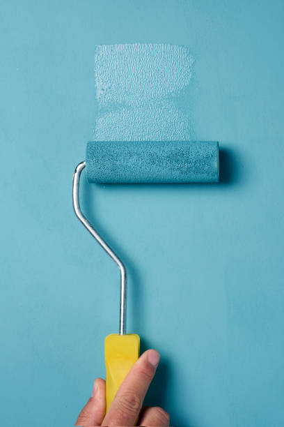 istock young man painting with a paint roller 886830312