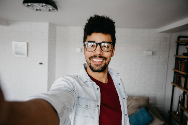 istock Smiling african man taking selfie at the apartment 886838298