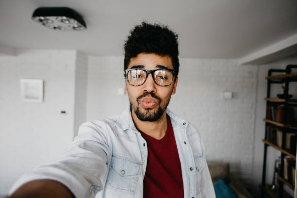 istock Funny african ethnicity man sends kisses to a camera 886840666