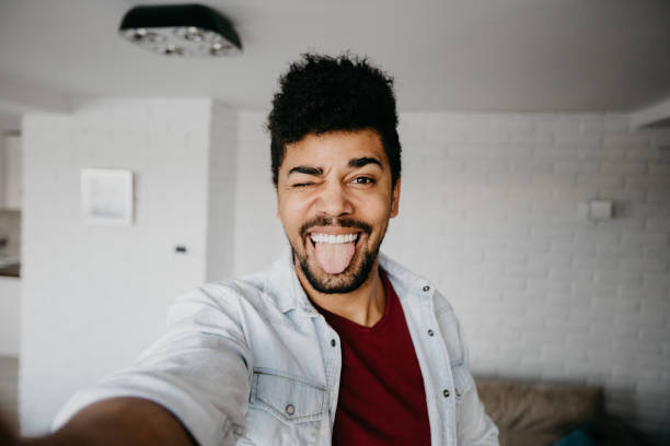 Man winking to a camera and taking a selfie