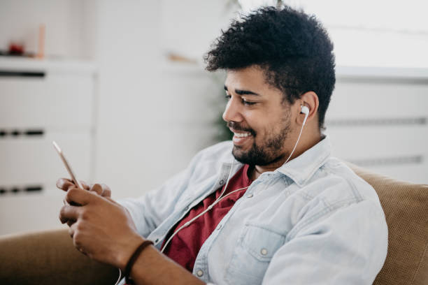 istock Smiling man using mobile phone to play video games 886841334