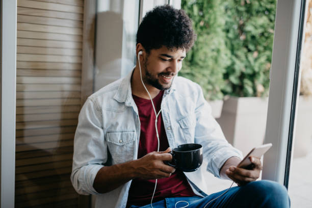 istock Man sitting on the steps listens to podcast 886841336