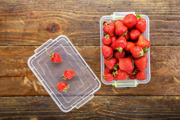 istock ripe organic strawberry  in a plastic container on a wooden background 886848012