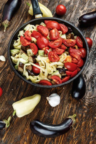 istock Sliced fresh vegetables in pan with spices and ingredients on wooden table 886850426