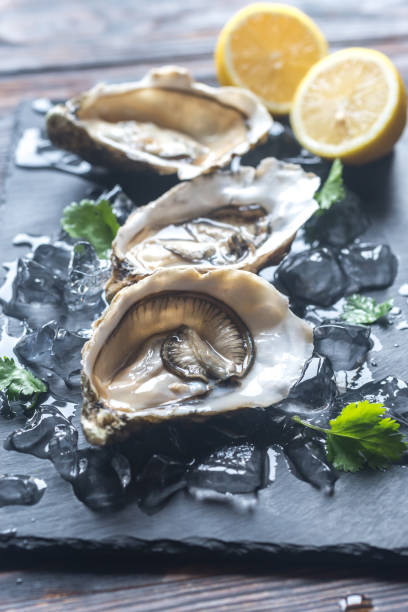 ブラック ボードに石生牡蠣 - prepared oysters prepared shellfish shucked seafood ストックフォトと画像