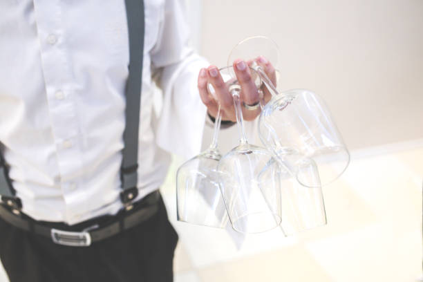 Medium section shot of unrecognizable African American waiter working in restaurant polishing wine glass