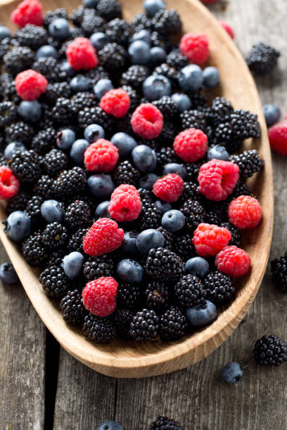 istock summer wild berries on wooden surface 886864610