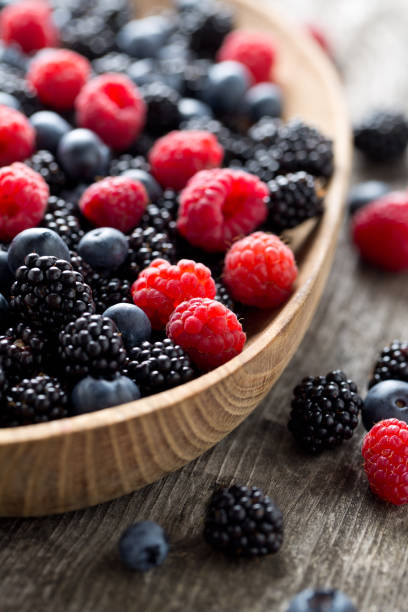 istock summer wild berries on wooden surface 886864646