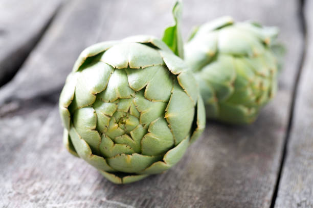 istock artichokes on wooden surface 886864910