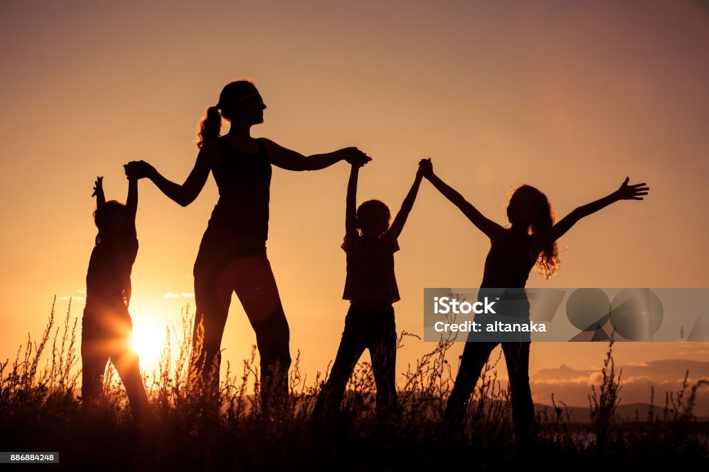 Happy family standing in the park. Happy family standing near the lake at the day time.  Concept of friendly family. Active Lifestyle Stock Photo