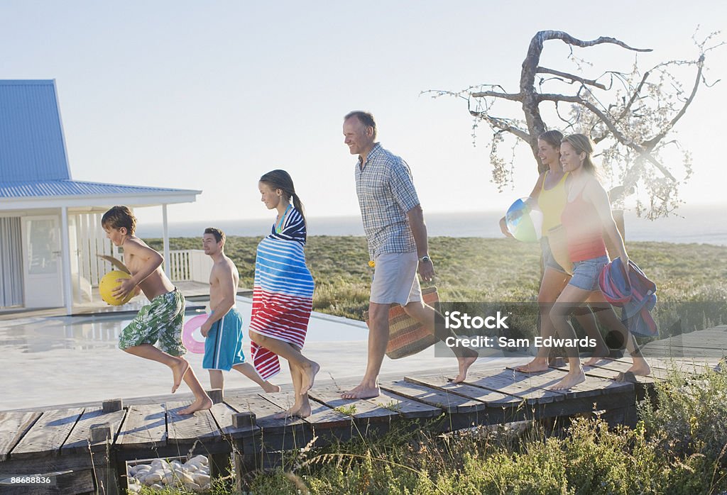 Família correndo no pier próximo à piscina - Foto de stock de Casa royalty-free