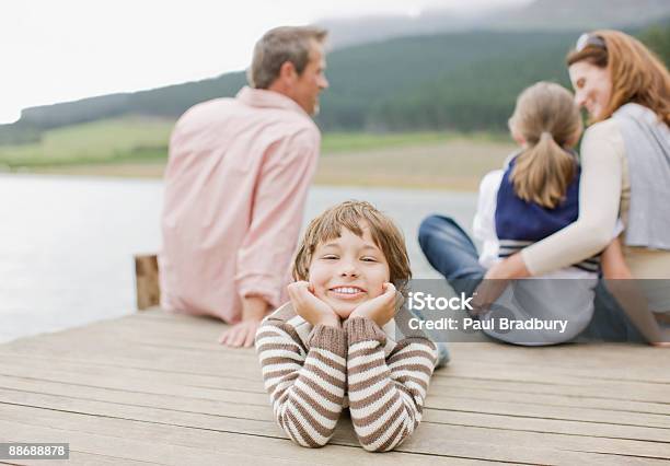 Familie Sitzt Auf Dem Pier Von Lake Stockfoto und mehr Bilder von 35-39 Jahre - 35-39 Jahre, 40-44 Jahre, 8-9 Jahre