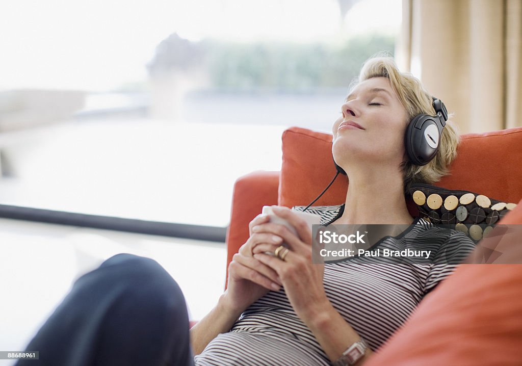 Frau, die Kopfhörer Musik hören auf sofa - Lizenzfrei Musik Stock-Foto