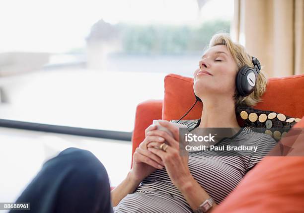 Frau Die Kopfhörer Musik Hören Auf Sofa Stockfoto und mehr Bilder von Musik - Musik, Zuhören, Frauen