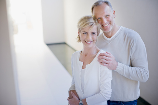 Portrait of loving mature couple smiling together against white background