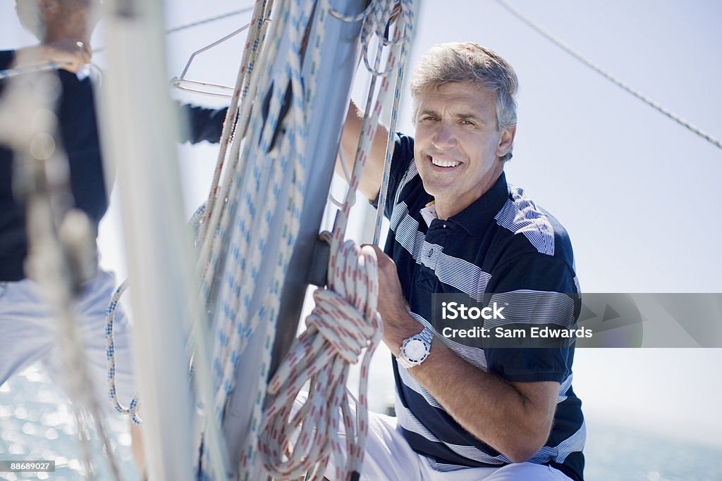 Uomo uno squat in barca a vela - Foto stock royalty-free di Andare in barca a vela