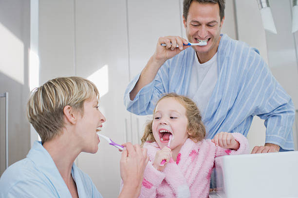 família escovar os dentes juntos - human teeth child smiling family imagens e fotografias de stock