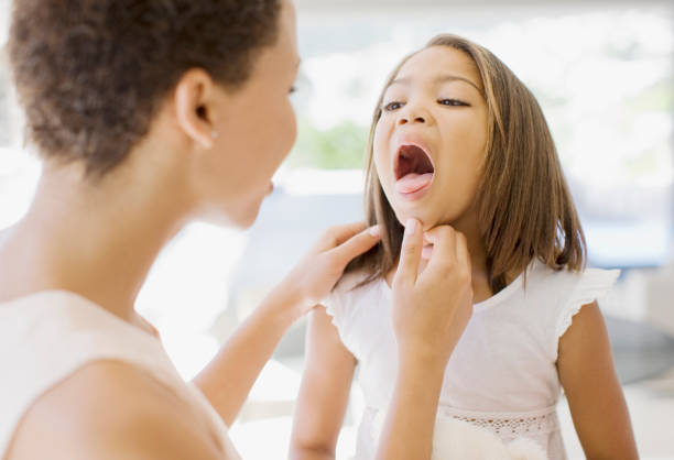 Woman checking sick daughters throat  sore throat stock pictures, royalty-free photos & images