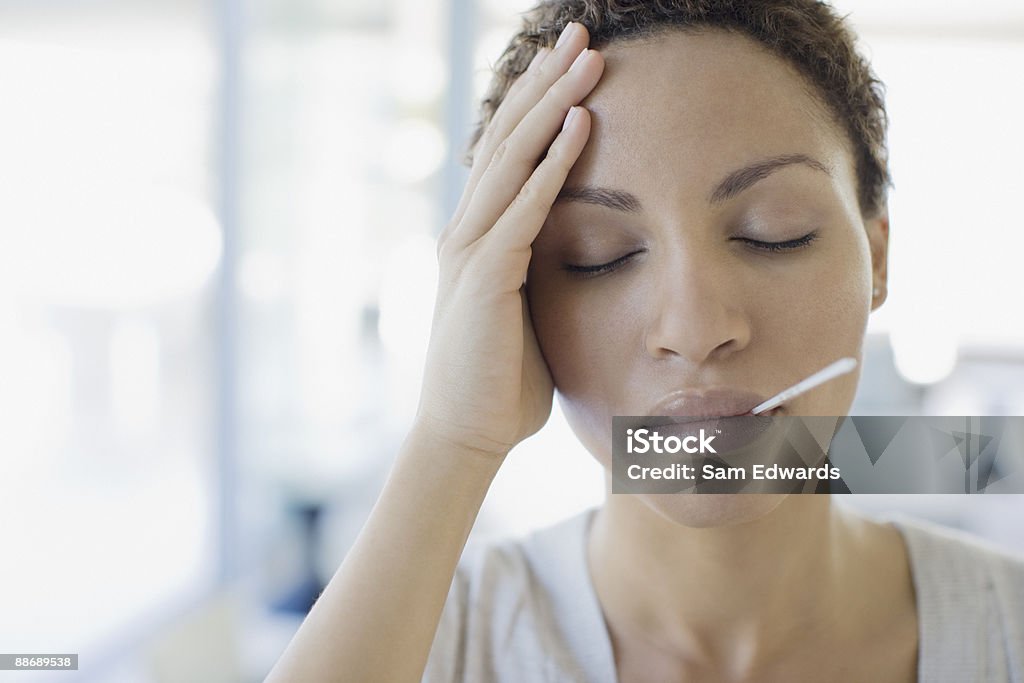 Sick mujer tomando su temperatura - Foto de stock de Fiebre libre de derechos