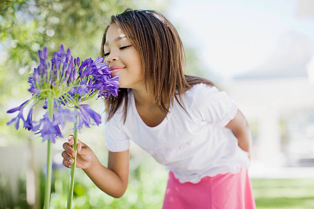 młoda dziewczyna zapachu kwiatów - lawn little girls small child zdjęcia i obrazy z banku zdjęć
