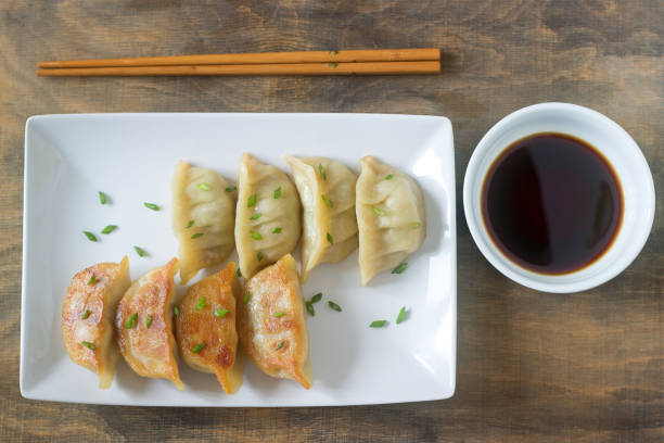 istock Eight boiled or fried jiaozi or gedza served with soy sauce. 886921304