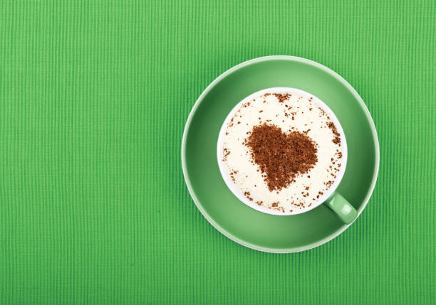 istock Close up latte cappuccino coffee in cup on green 886933606