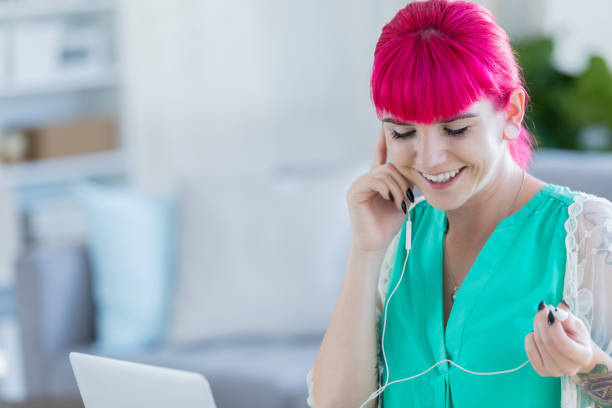 istock Happy woman listens to music while working 886933674