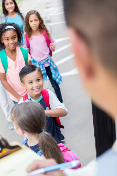 istock School bus driver greets school children 886933804
