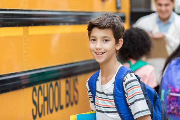 istock Happy schoolboy preparing to board bus 886933810