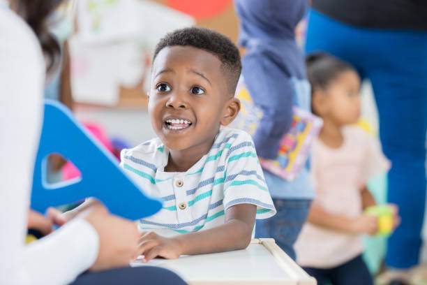 niño emocionado reconoce la letra a en el preescolar - child discovery surprise playing fotografías e imágenes de stock