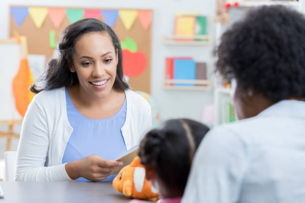 дошкольное учитель приветствует нового студента и маму - teacher parent education meeting стоковые фото и изображения