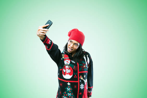 istock Christmas Sweater Woman Taking Selfie 886942288