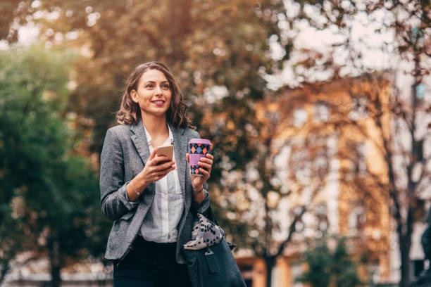 istock Woman texting and drinking coffee outdoors 886946152