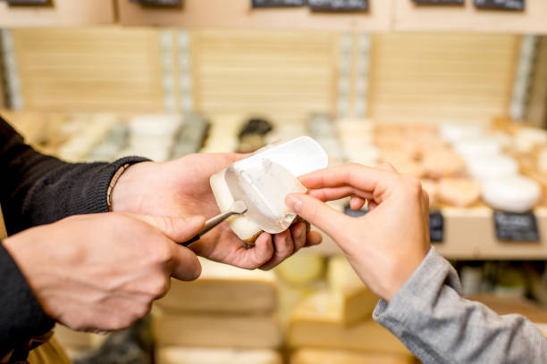 istock Cutting a cheese for woman customer 886947954