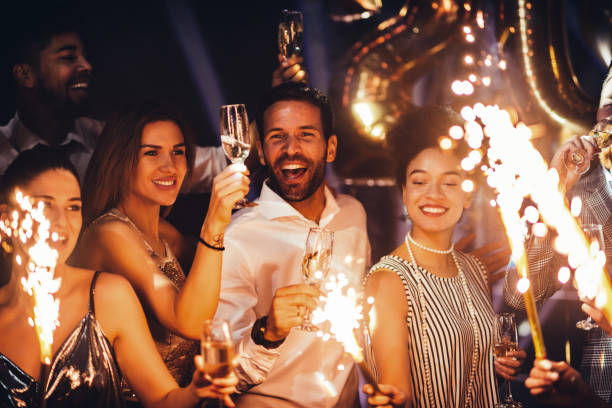 Celebrating with closest people Cropped shot of young friends holding sparklers at a party happy new year stock pictures, royalty-free photos & images