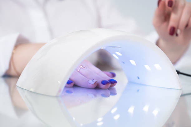 istock Female hand close up. Manicure. Ultraviolet lamp 886949878