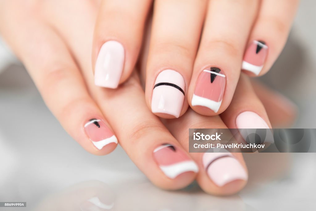 Beautiful female hands with a fashionable manicure. Geometric design of nails. Photo closeup Fingernail Stock Photo