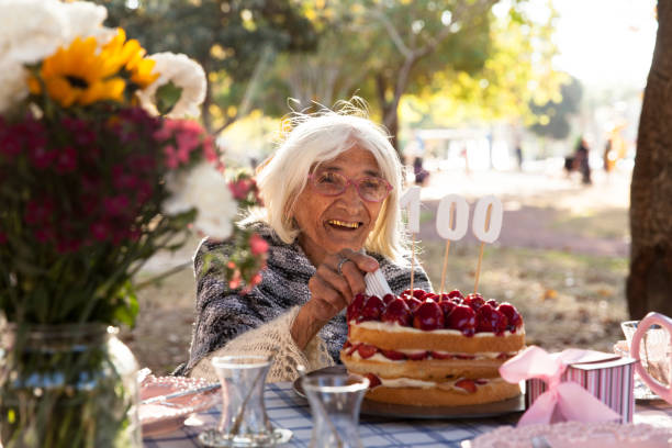 istock Senior woman cutting cake 886956004