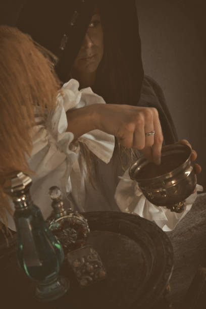 istock Female Wizard mixing potion at table with Magical Items 886964110