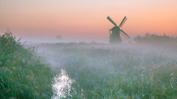 istock Dutch Polder landscape with traditional windmill 886972724