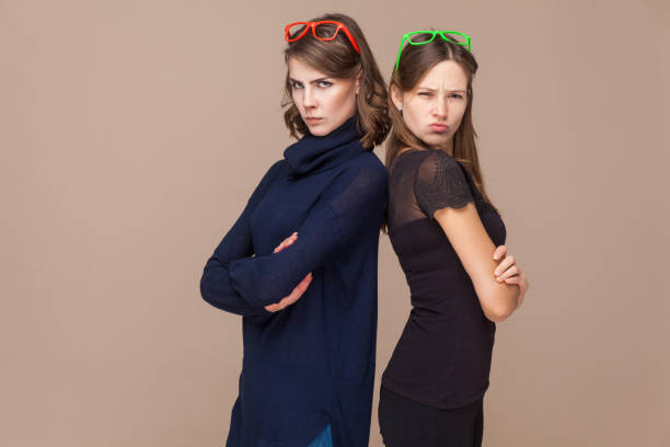 istock Two colleagues standing back to back and looking at camera seriously. 886978456