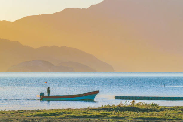 AYSEN, CHILE, APRIL - 2017 - Adult man driving small boat at Carrera lake in patagonia territory, Aysen district, Chile