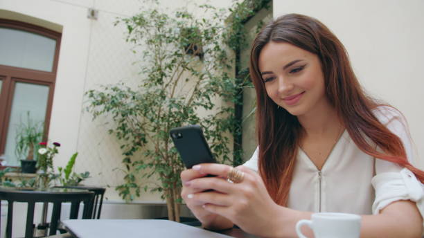 istock Beautiful Girl Using a Mobile Phone in the Room 887013374