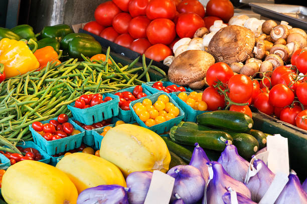 istock Vegetables on stands in an outdoors market. 887018388