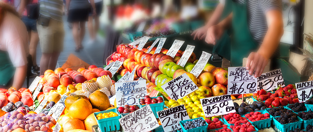 Fruits with tag prices on stands in an outdoors fruit market in Seattle, Washington.