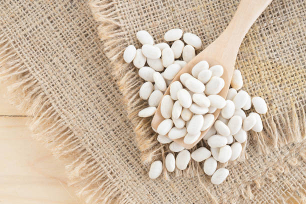 istock white bean in wood spoon on sack background 887031472